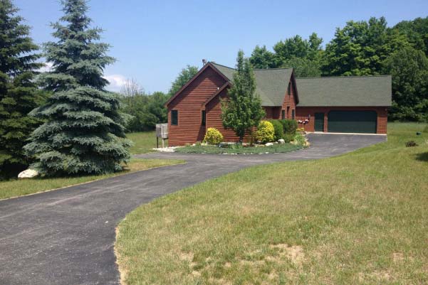 Discover other pieces of land for sale in Northern Michigan like the Alden Meadows development in Antrim County with this stately log home with 2-car garage and walkout basement.