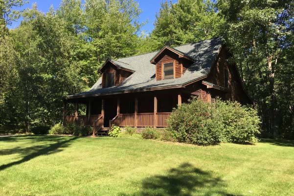 A classic log home with covered front porch surrounded by mature hardwoods located on a estate-sized parcel of property in Northern Michigan.