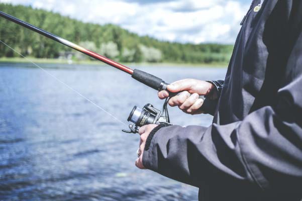 Close up image of a man slowly reeling in a fish on a small inland lake in Kalkaska County, Michigan.