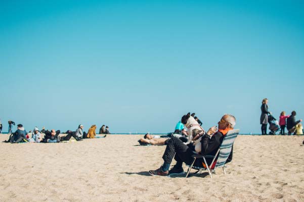 People sitting on the beach enjoying a clear sunny day in Grand Traverse County.