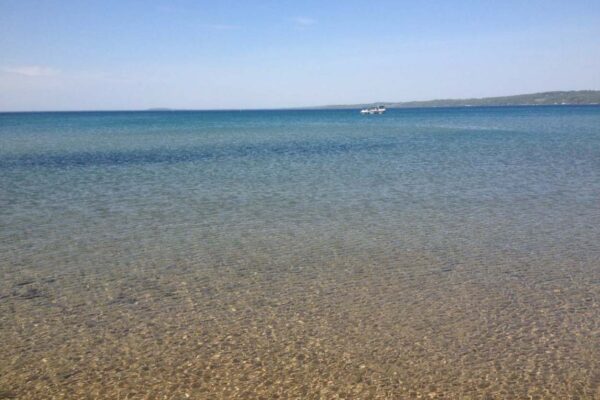 View of boats on Torch Lake from the beach.