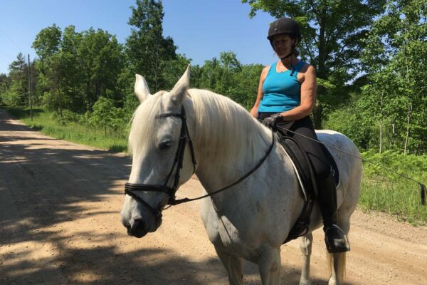 Woman riding a white horse on the trails near the Metzgar Road property.