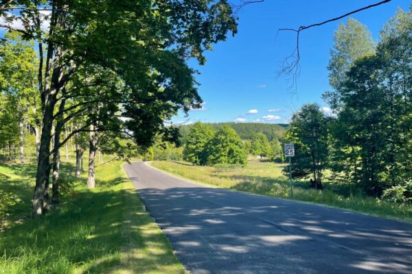 A long stretch of two-lane blacktop road through the green countryside at Paradise Ranch near Kingsley, MI.