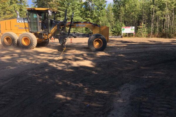 Heavy machinery grading and cleaning up a dirt road at Silverado Estates in Grand Traverse County.